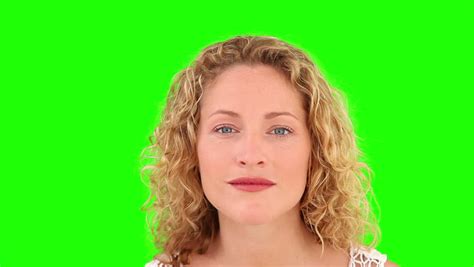 Curly Blond Haired Woman Putting On Make Up Against A Green Screen Stock Footage Video