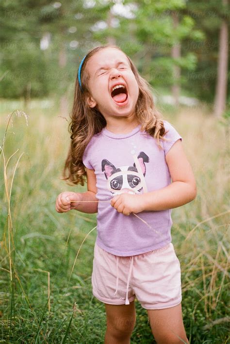 Cute Babe Girl Making A Funny Face In A Field By Stocksy Contributor