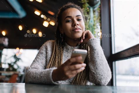 Portrait Of Charming Dark Skinned Model With Modern Cellphone In Hand