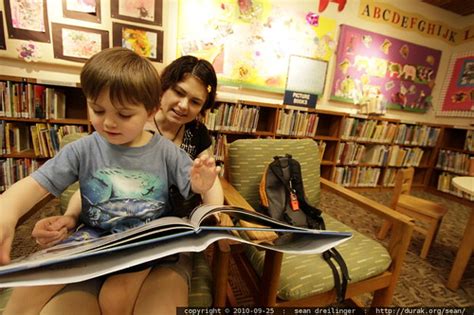 Photo In The Childrens Library Reading A Book In Moms Lap By
