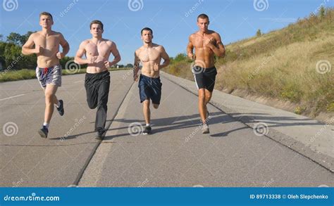 group of runners men jogging at highway male sport athletes training outdoor at summer stock