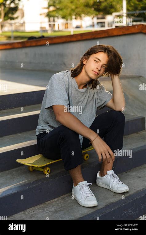 Photo Of Caucasian Skater Boy 16 18 In Casual Wear Sitting On