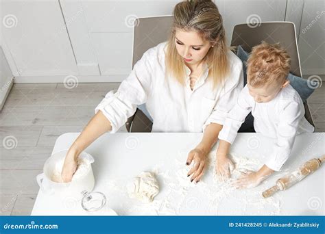 Maman Et Son Fils Cuisinent Ensemble Dans Une Cuisine Blanche à Partir De Pâte Image Stock
