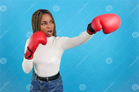 Aggressive African Woman Wearing Boxing Gloves Throwing A Punch Stock