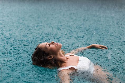 Woman In A Pool Swimming In The Rain By Jessica Lia Stocksy United
