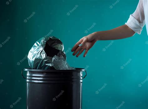 Premium Ai Image A Woman Throwing A Trash Bag In A Bin On Green