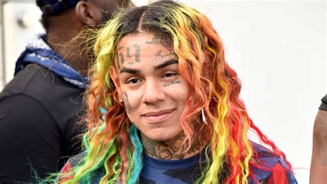 A Man With Multicolored Dreadlocks On His Face And Chest Standing In