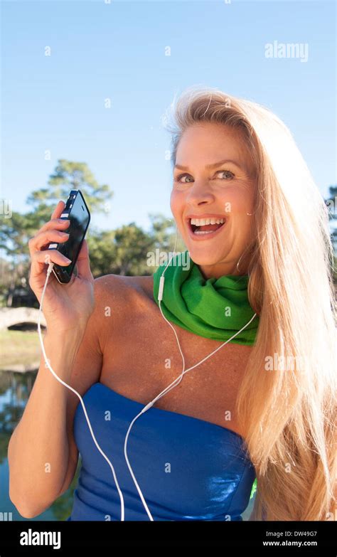 Young Attractive 50 Year Old Woman Listening To Music On Cell Phone