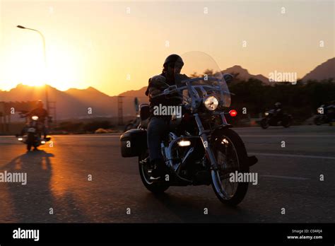 A Group Of Harley Davidson Bikers Rides Out Into The Desert As The Sun