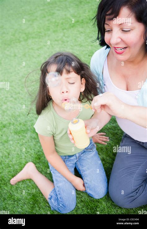 Madre E Hija Hispana Soplando Burbujas Fotografía De Stock Alamy