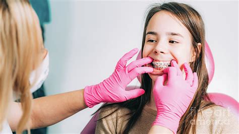 Orthodontist Fixing Girl S Dental Braces Photograph By Microgen Images Science Photo Library