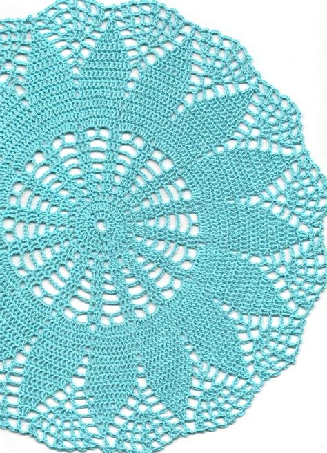 A Crocheted Doily Is Shown On A White Surface