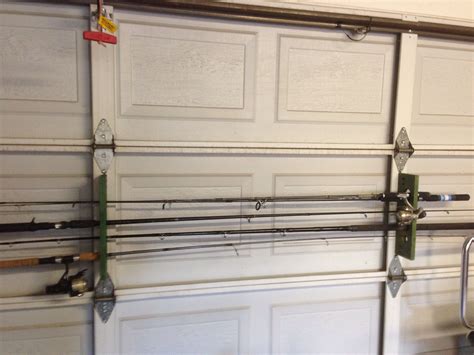 Fishing Rod Holder Made From Pallet Wood And Hung On The Garage Door