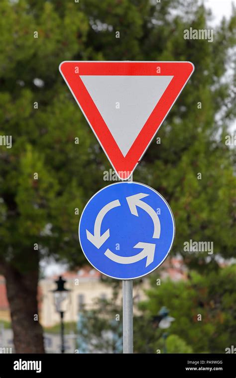 Triangle And Roundabout Traffic Signs At Circular Intersection Approach