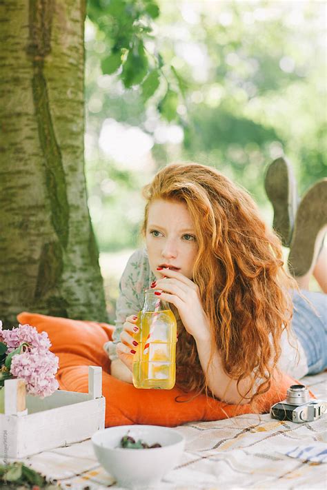 Ginger Woman Drinking Juice On A Picnic By Lumina