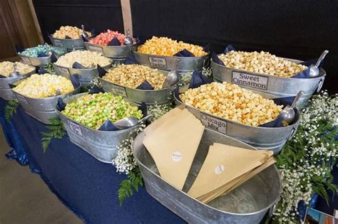 Several Buckets Filled With Different Types Of Popcorn On A Blue Cloth