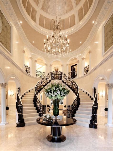 A Spacious Foyer With A Domed Ceiling And Double Staircase Makes A