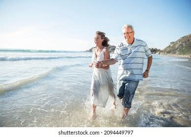 Older Couple Playing Waves On Beach Stock Photo 2094449797 Shutterstock