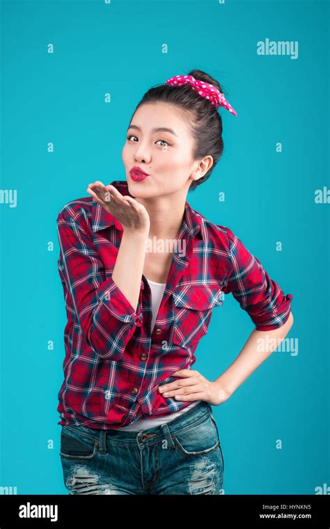 Smiling Lovely Asian Woman Dressed In Pin Up Style Dress Over Blue