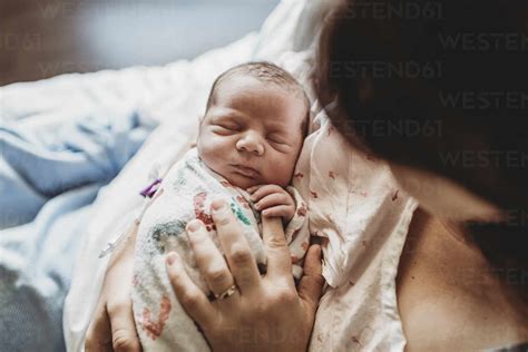 Overhead View Of Mother Holding Newborn Boy S Fingers In Hospital Bed