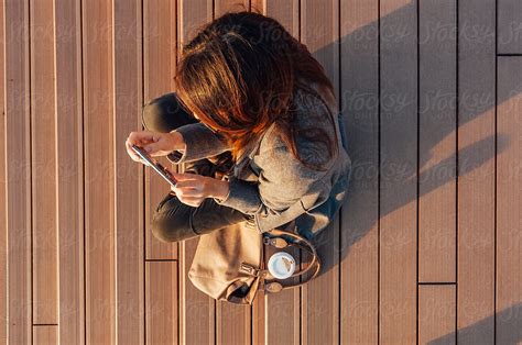 Young Woman Sitting On The Platform In The Sunset Del Colaborador De Stocksy Dimitrije