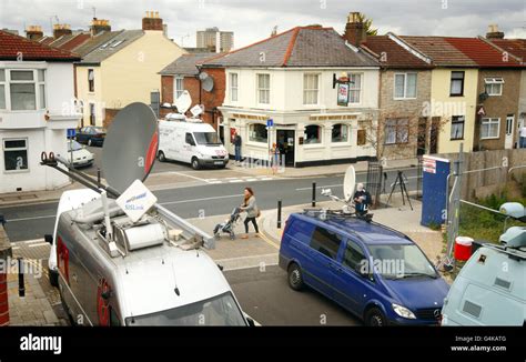 Television Satellite Trucks Surround The Red White And Blue Pub In