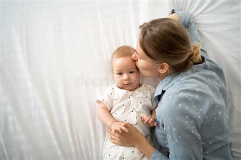 Top View Caucasian Mother And Her Toddler Baby On The Bed Close Up