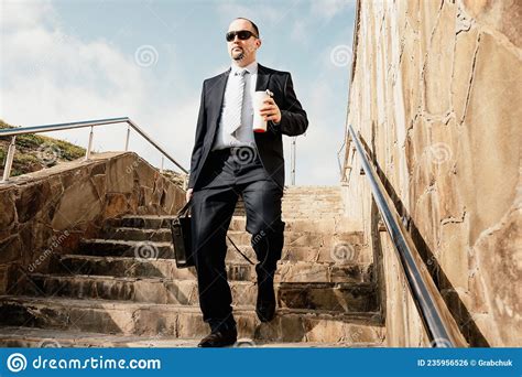 Confident Middle Age Businessman With Briefcase Walking Upstairs Close