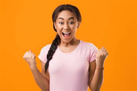 Excited Student Celebrating Success Over Orange Background Stock Photo