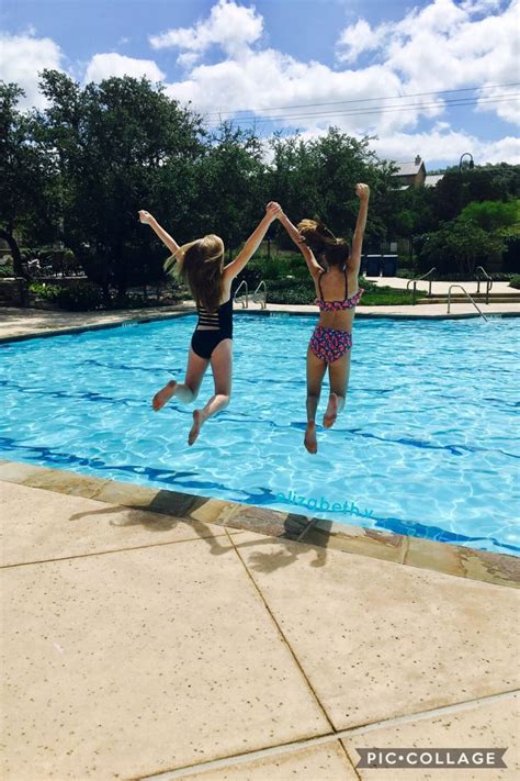 Two Girls Jumping Into A Swimming Pool With Their Arms In The Air