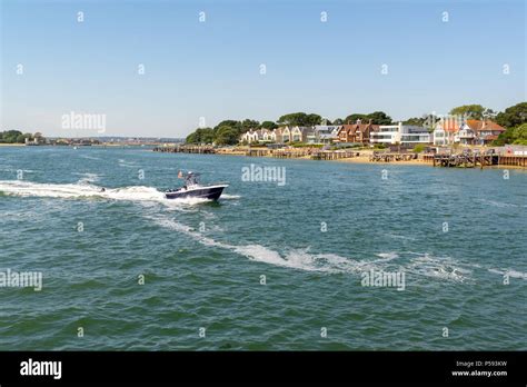 A Boat Speeding Out Of Poole Harbour Dorset England Uk And Past Some