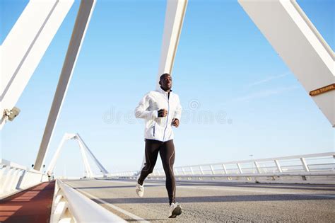 A Beautiful Dark Skinned Athlete Running On The Big Bridge Stock Image