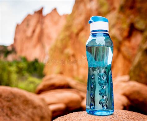 Aqua Blue Fitness Water Bottle With Mountains In Background Stock Photo