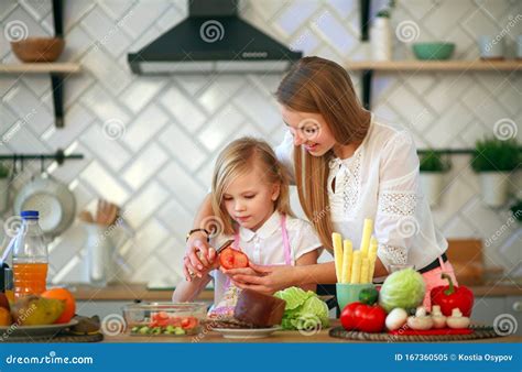 Mother Teaches Her Child Daughter How To Cook In Kitchen Parenthood