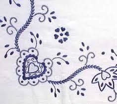 An Embroidered White Sheet With Blue Flowers And Hearts