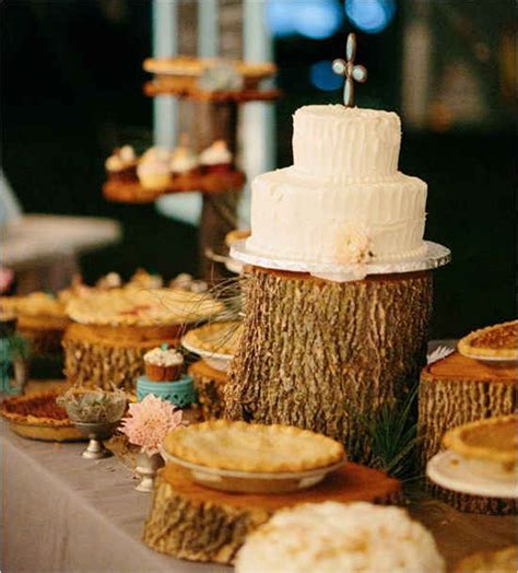 A Table Topped With Lots Of Cakes And Pies On Top Of Wooden Stumps