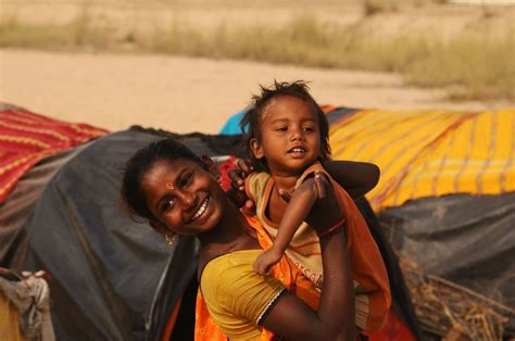 A Young Gypsy Girl Stands With Her Son In Front Of Her Makeshift Hut On The Bank Of Ajay River