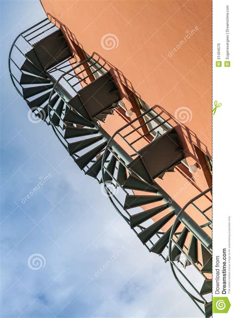 Old Metal Spiral Ladder On The Red Wall Stock Photo Image Of Clouds