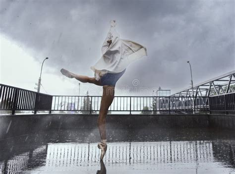 Ballerina Dances In The Rain On The Street While Walking Around The