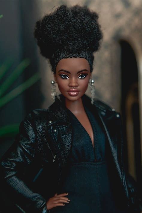 A Barbie Doll Wearing A Black Dress And Leather Jacket With Her Hair In A Bun