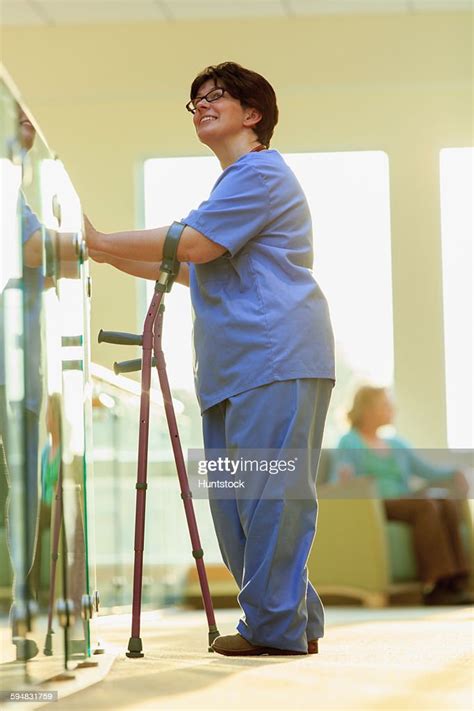 Nurse With Cerebral Palsy Walking Down The Hallway Of A Clinic With Her Canes High Res Stock