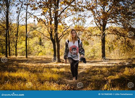 Beautiful Young Girl Walking Barefoot With Sneakers In Hand Into The