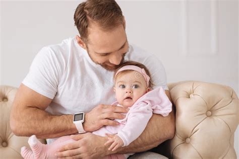 Young Careful Man Sitting On The Couch With His Baby Stock Image