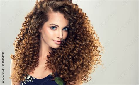 Brunette Girl With Long And Shiny Curly Hair Beautiful Model Woman With Wavy Hairstyle ภาพถ่าย