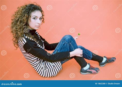 De Tiener Gaat Zitten Tegen Een Oranje Achtergrond Stock Foto Image