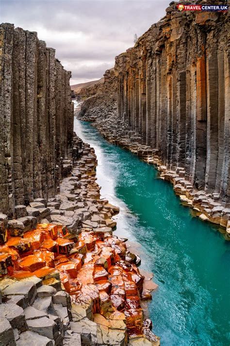 The Blue Water Is Flowing Between Two Large Rock Formations And There