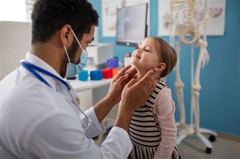 Young Male Doctor Checking Little Girls Lymph Nodes In His Office Stock