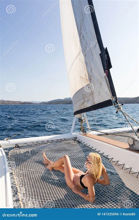 Beautiful Woman Relaxing On A Summer Sailing Cruise Lying And Sunbathing In Hammock Of Luxury