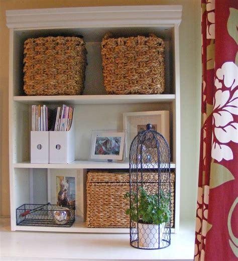 A Shelf With Baskets And Books On It Next To A Shower Curtain In A Bathroom