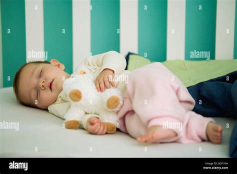 Baby Sleeping In Crib Holding Stuffed Toy Stock Photo Alamy